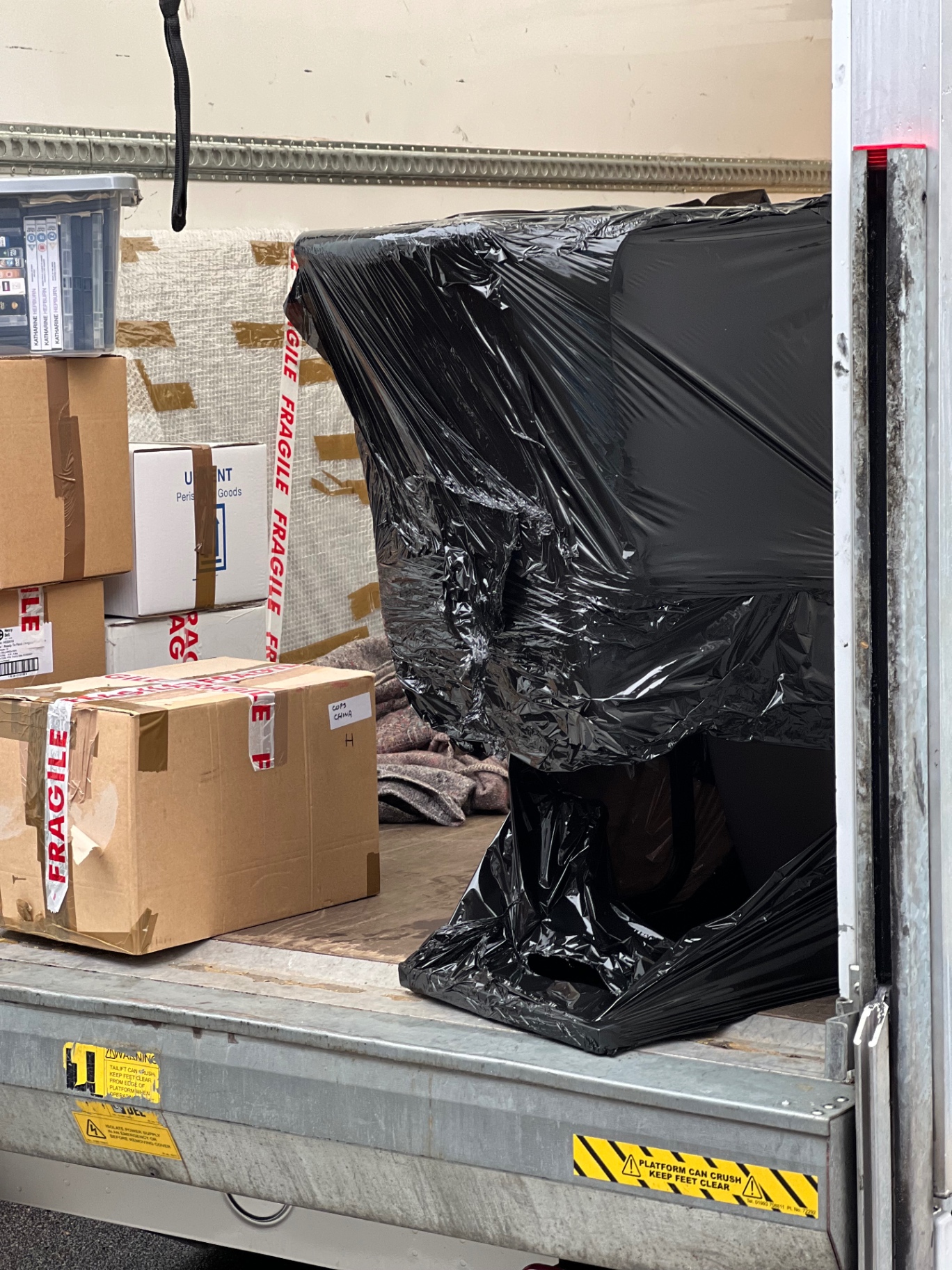 Furniture professionally wrapped in protective covers inside a removal van